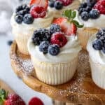 image of angel food cake cupcakes decorated with fresh berries and a dusting of powdered sugar