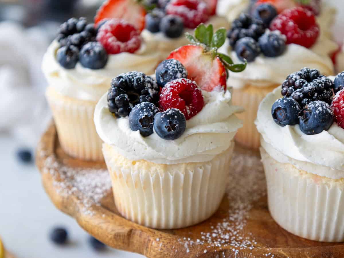 image of angel food cake cupcakes decorated with fresh berries and a dusting of powdered sugar