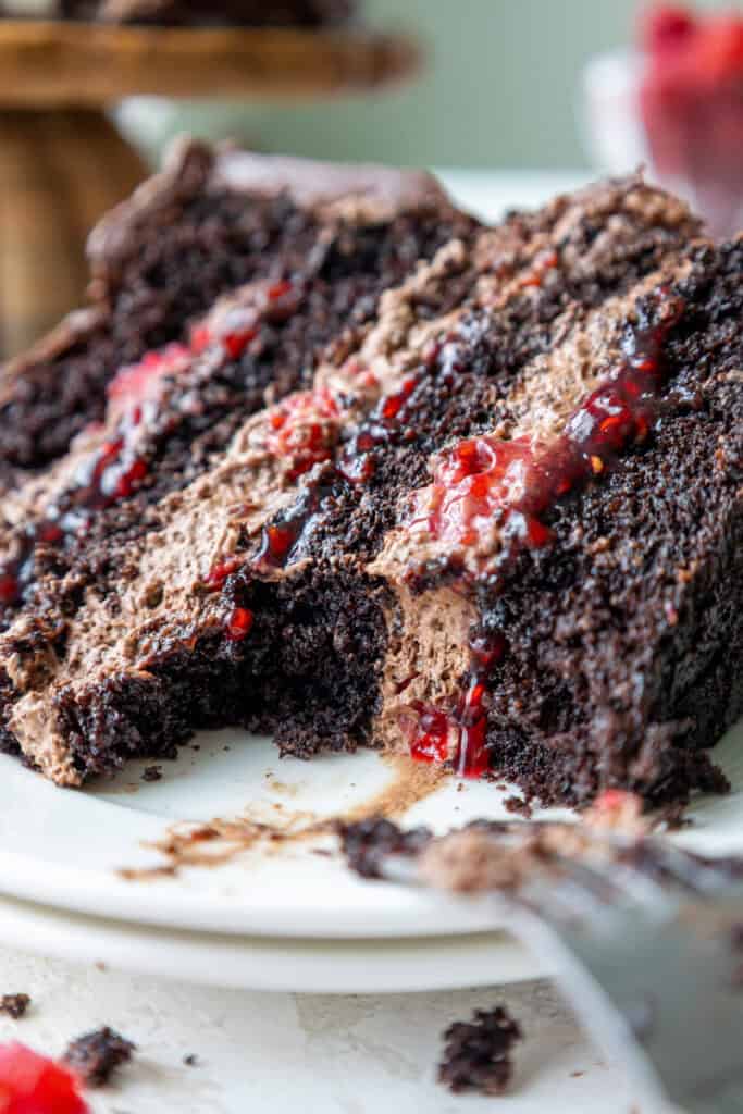 image of a chocolate raspberry mousse cake slice that's been cut into to show it's filling