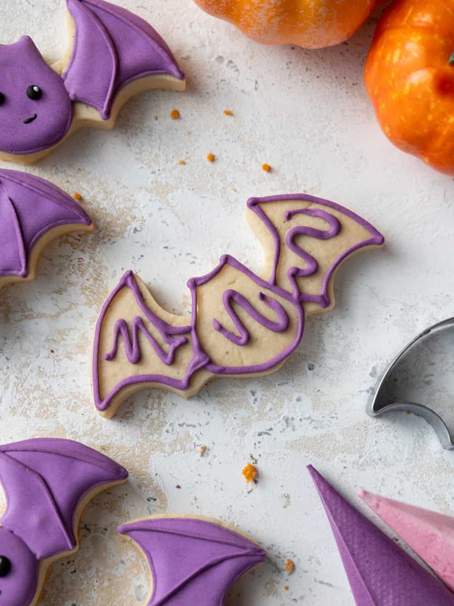 image of a bat cookie being outlined with royal icing