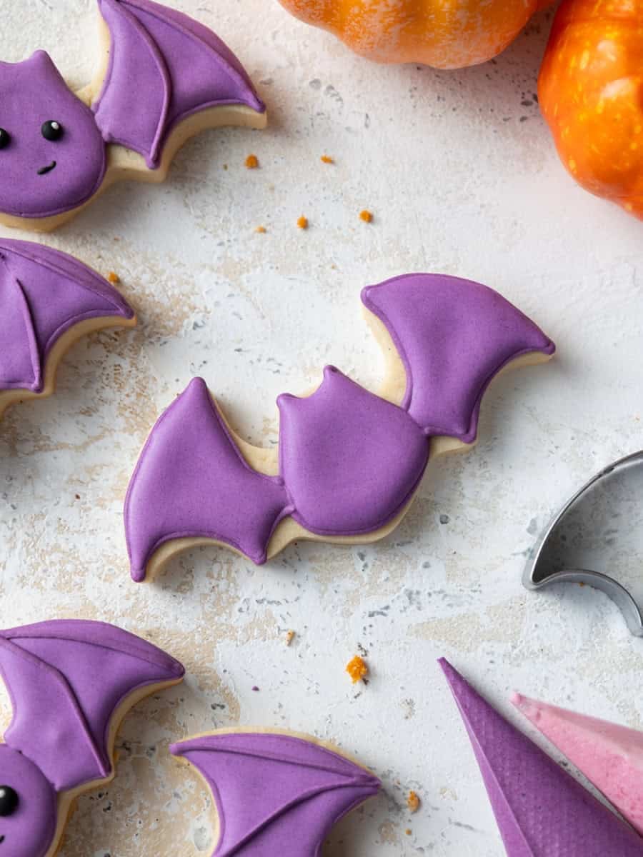 image of a bat cookie that's being decorated with purple royal icing