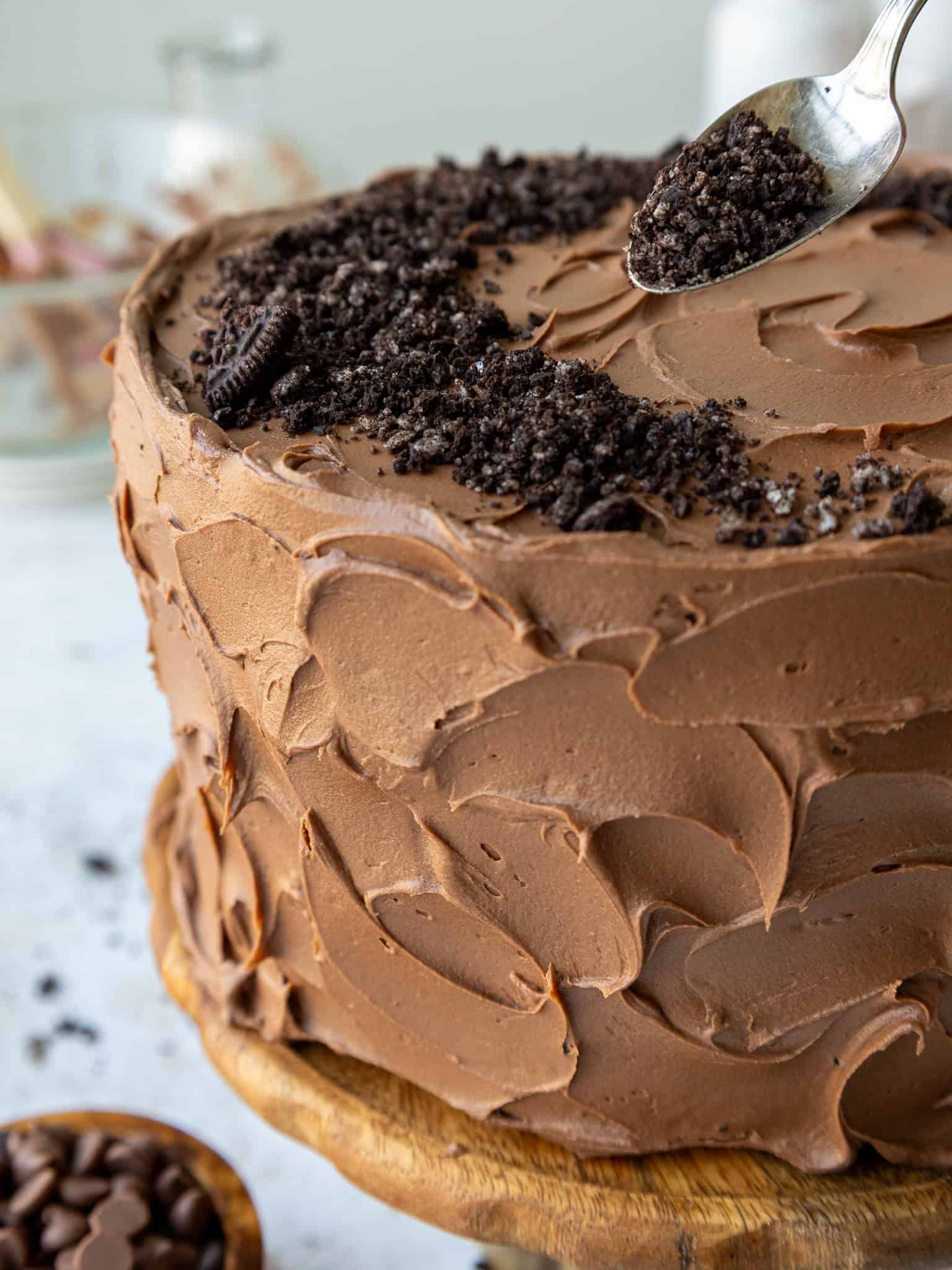 image of an Oreo fudge cake that's being topped with crushed Oreos