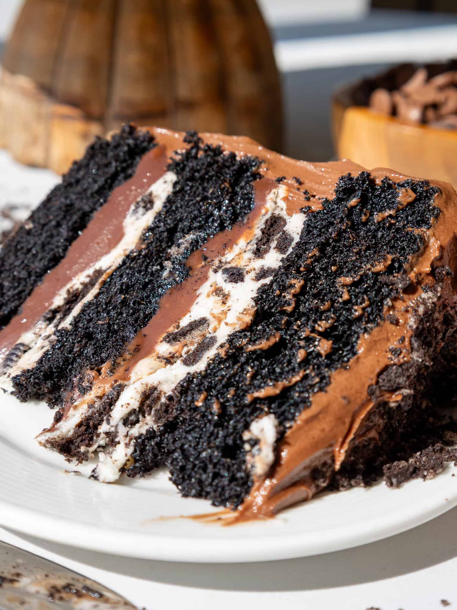 image of an Oreo fudge cake slice that's been cut into on a plate to show its Oreo frosting and fudge filling