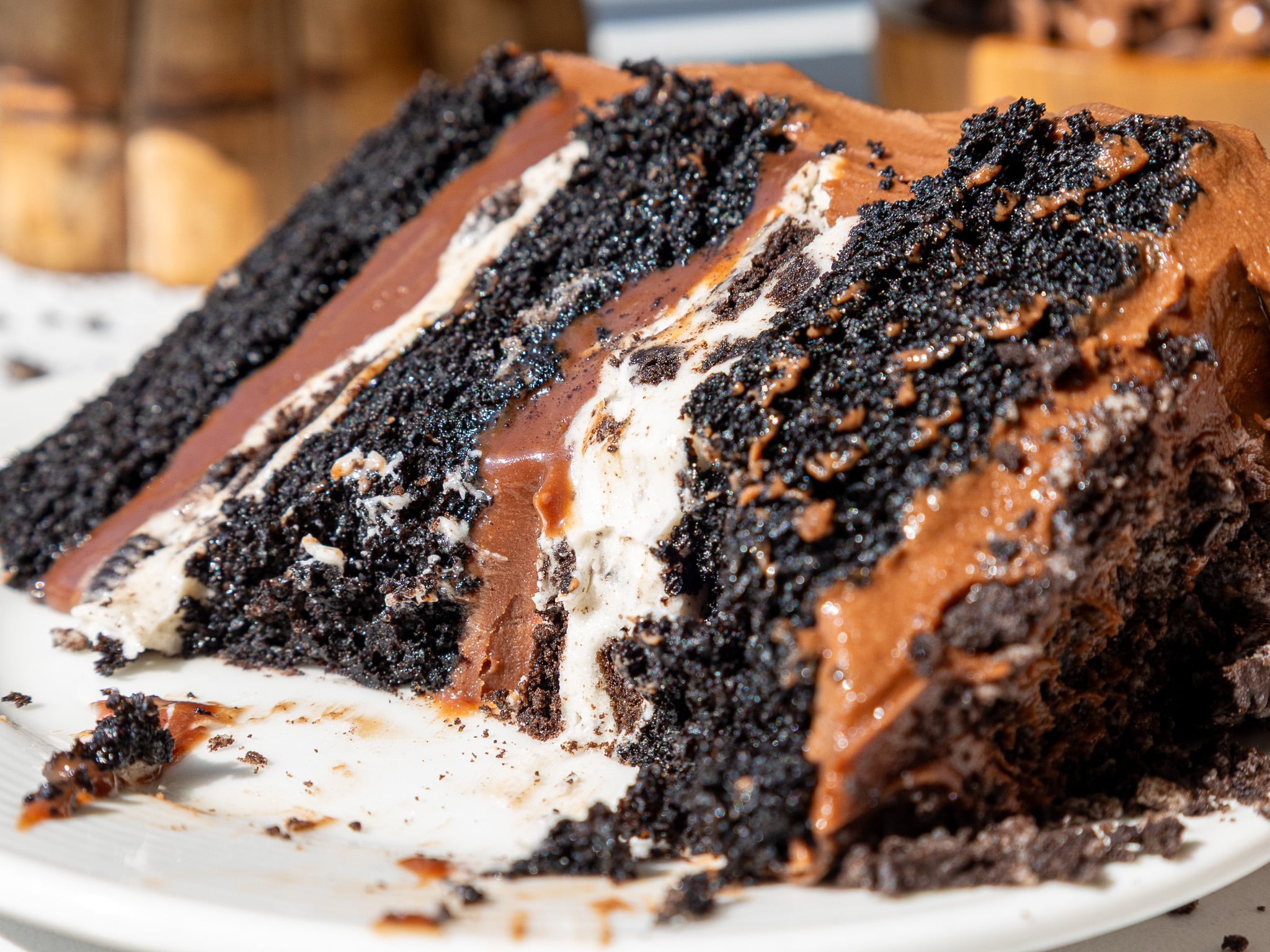 image of an Oreo fudge cake slice that's been cut into on a plate to show its Oreo frosting and fudge filling
