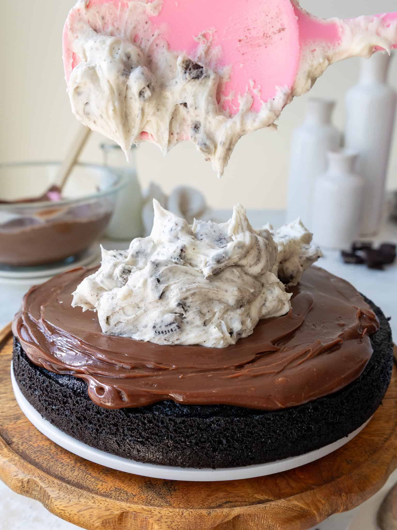 image of an oreo fudge cake being filled with chocolate ganache and Oreo buttercream