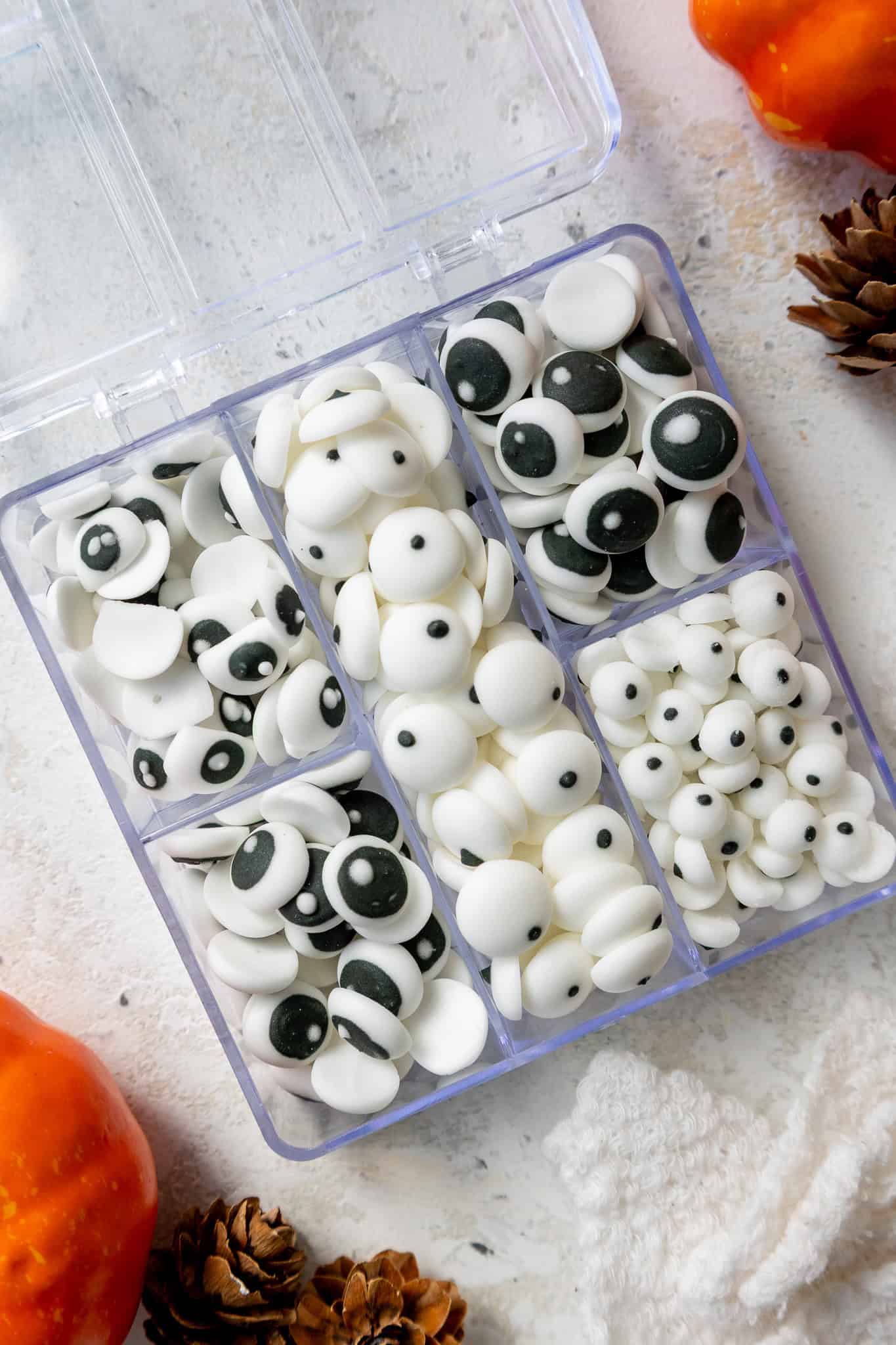 image of homemade candy eyes that have been sorted into a plastic container