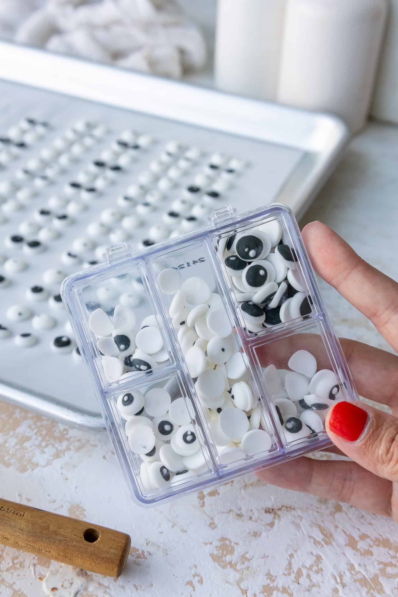 image of homemade candy eyes that have been sorted into a plastic container