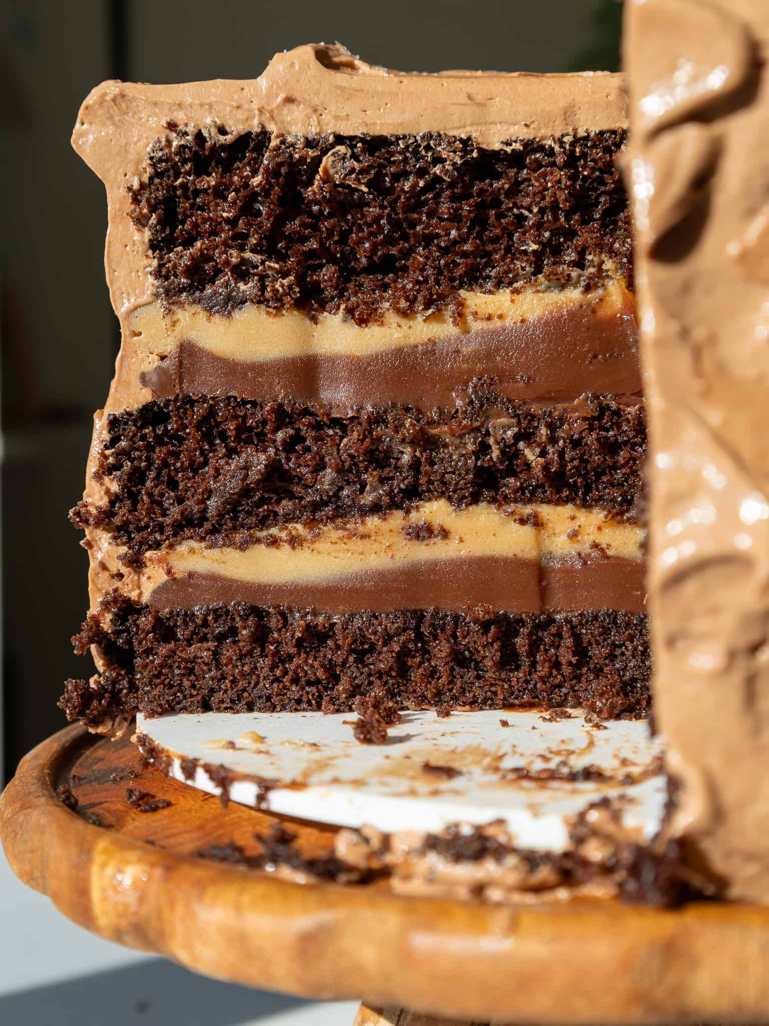 image of a peanut butter fudge cake that's been cut into to show it's chocolate and peanut butter ganache filling