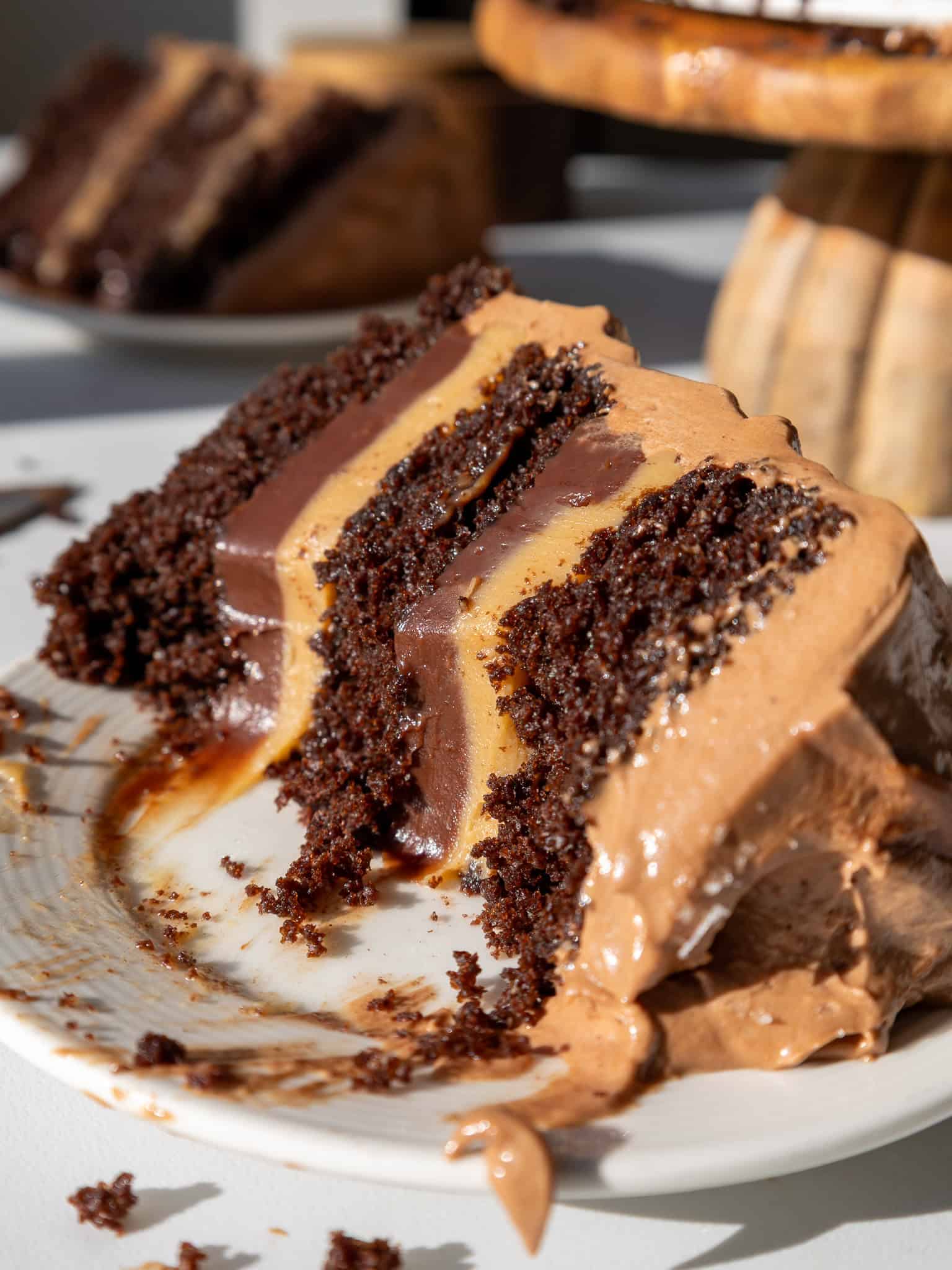 image of a slice of peanut butter fudge cake that's been cut into to show it's peanut butter and chocolate ganache filling