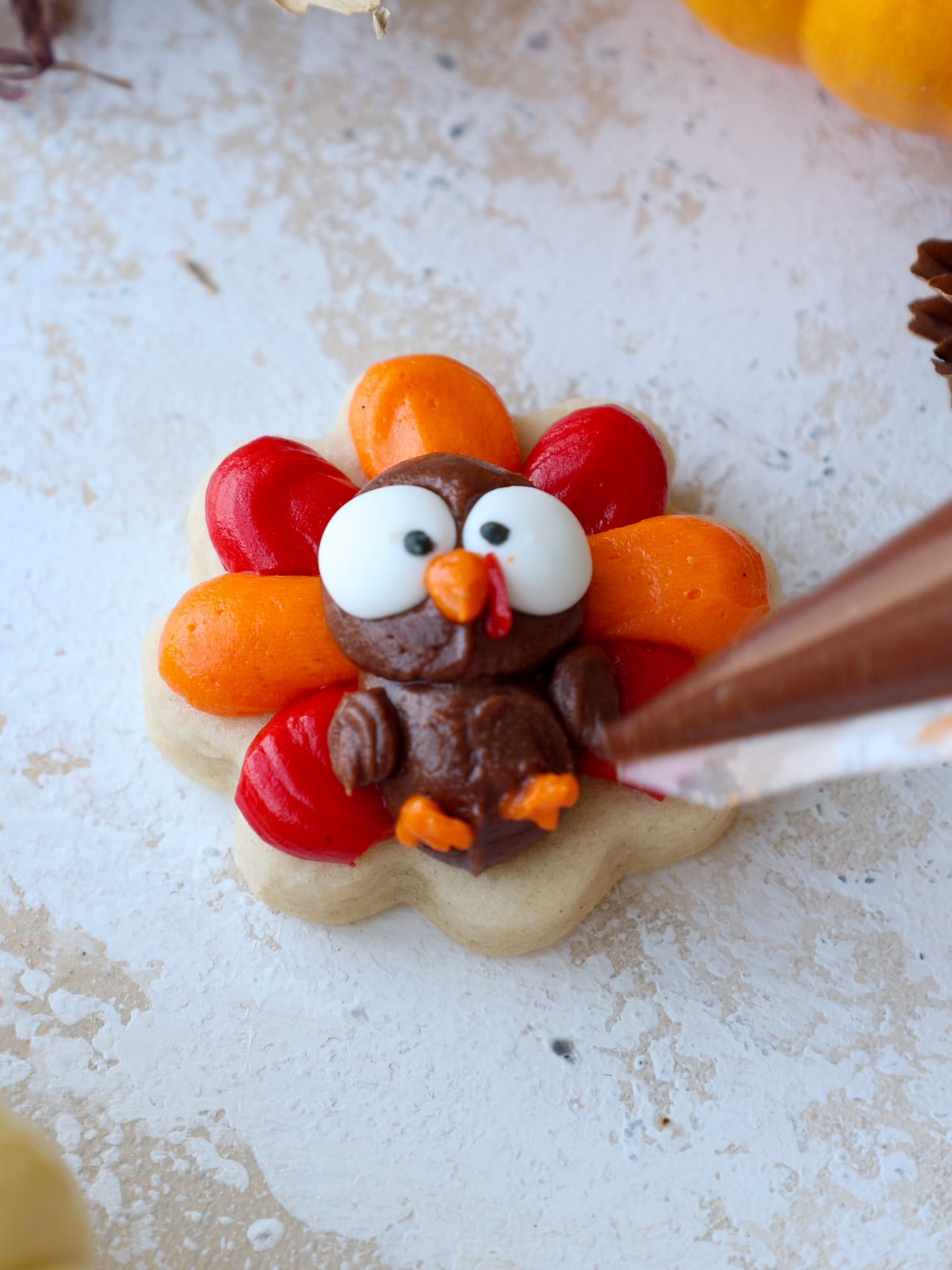image of finished buttercream turkey cookies decorated with wings and wattles