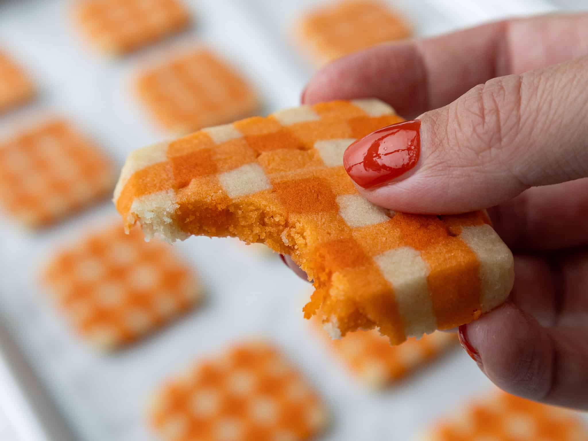 image of a gingham shortbread cookie that's been bitten into to show how tender it is