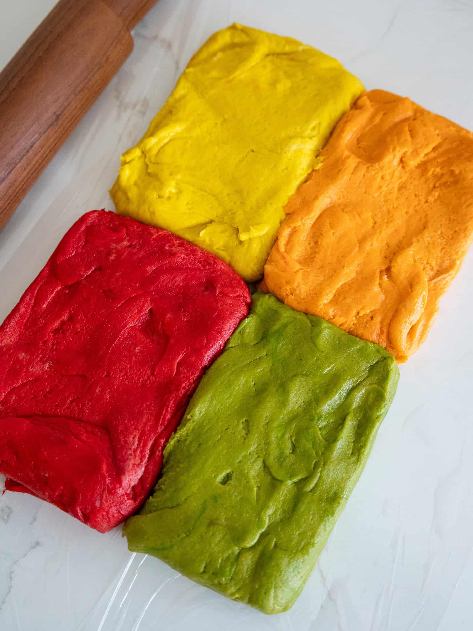 image of cookie dough that's been colored red, orange, yellow, and green with gel food coloring