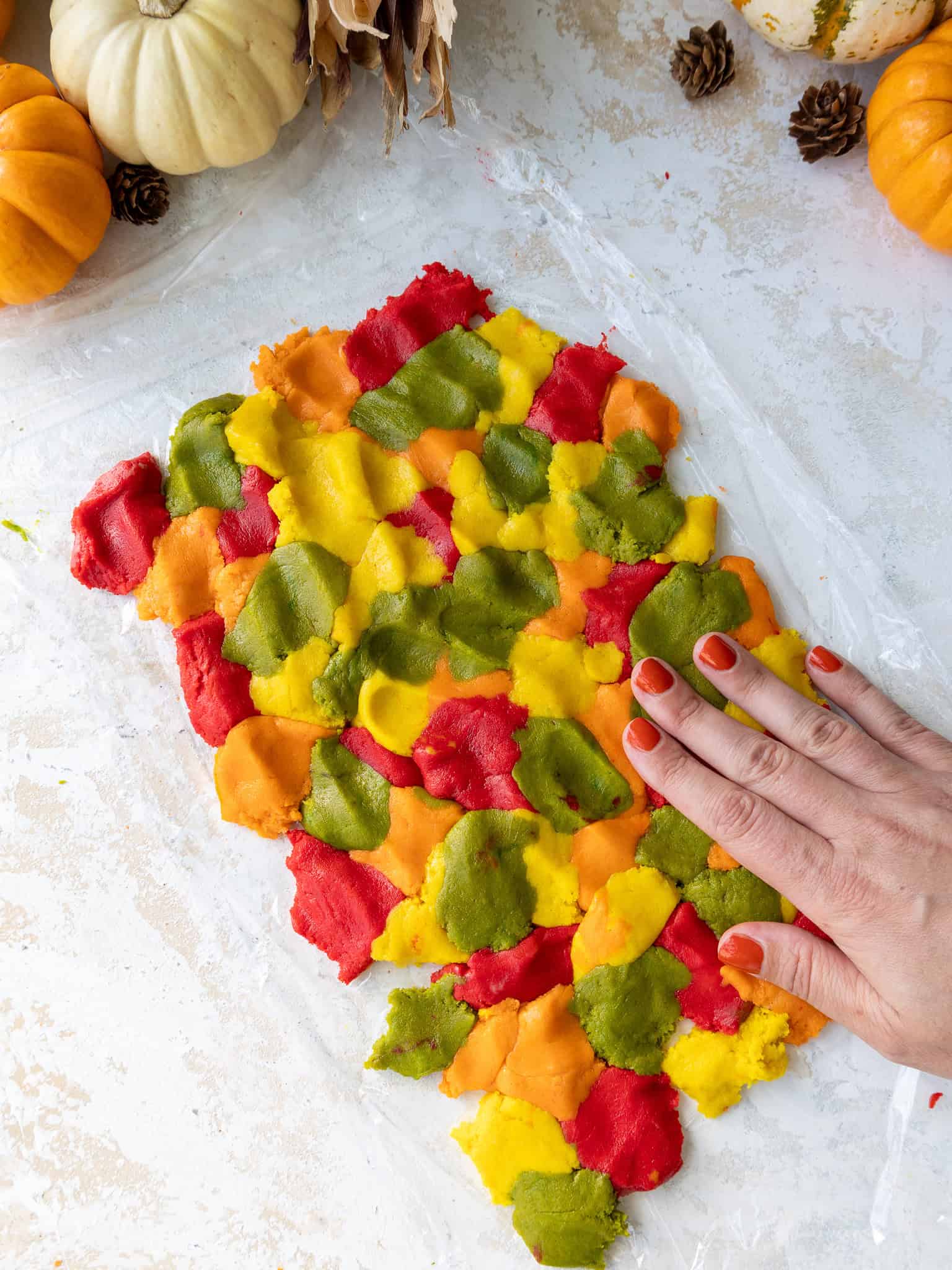 image of red, orange, yellow, and green cookie dough pieces arranged to create a marbled pattern