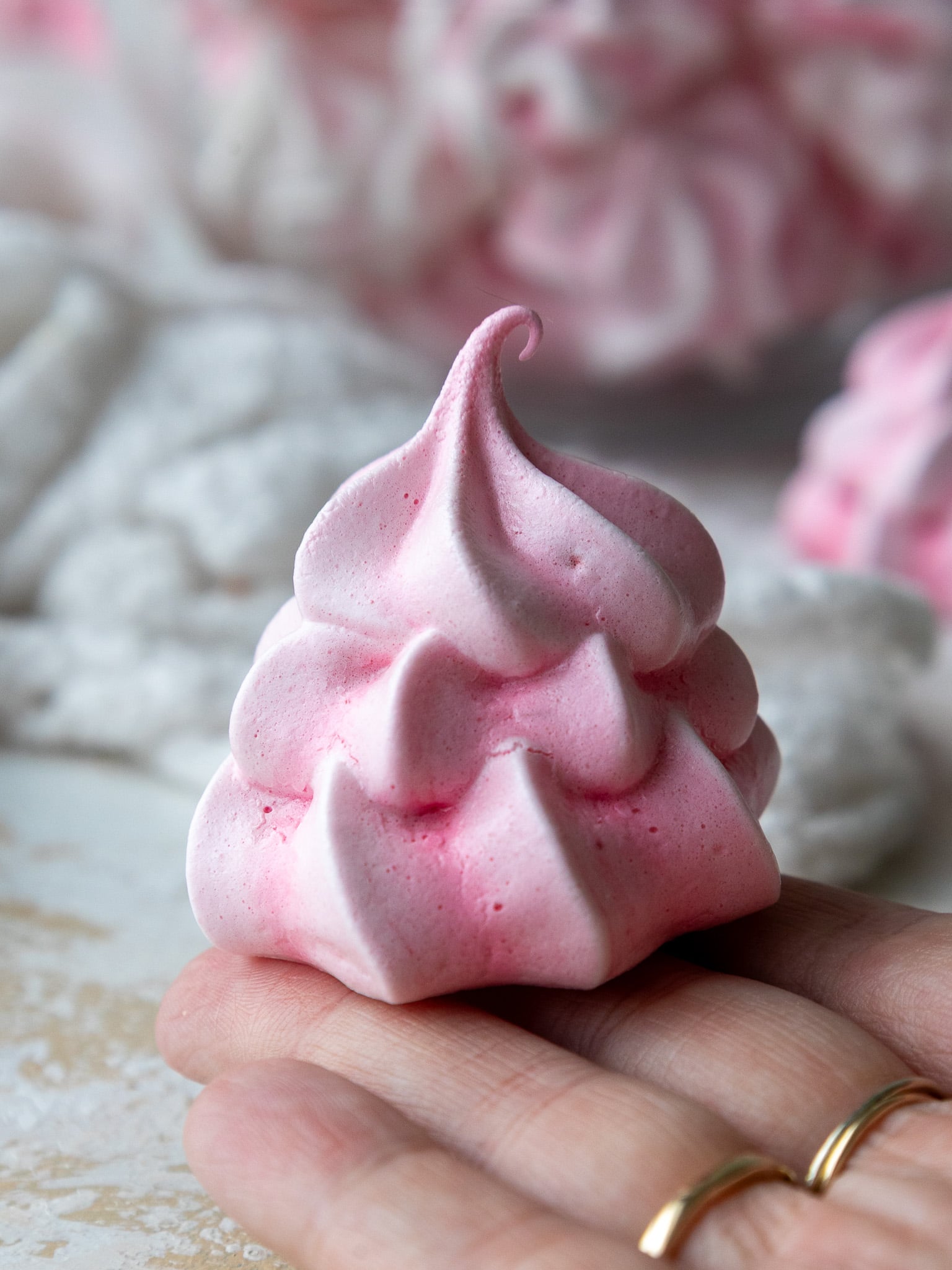 image of baked meringue cookies cooling on a parchment-lined baking sheet